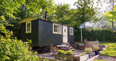 Exterior view of Meadow Hut with hot tub and seating area in Lombard Farm, Fowey, Cornwall 