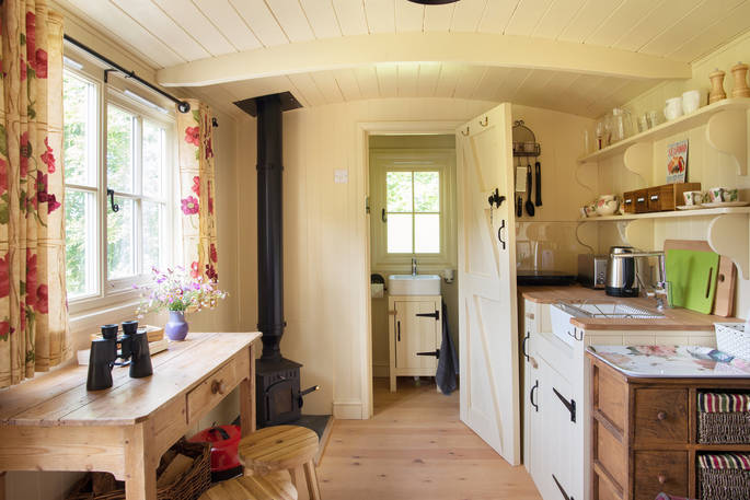 Interior of kitchen with wood burner and en suite bath room door open