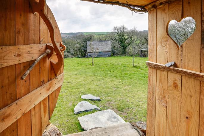 Looking out of the wooden hobbit door at the garden at Cornish Hobbit in Cornwall