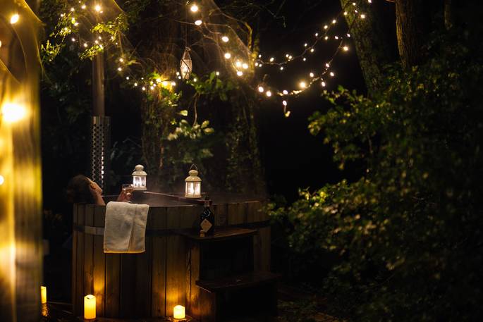 Hot tub surrounded by fairy lights for a relaxing stay