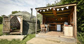 Croglin Yurt with outdoor covered kitchen and seating area at Drybeck Farm in Cumbria