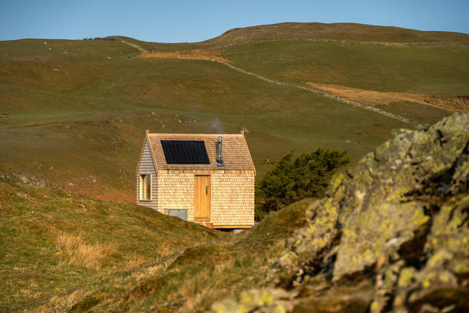 Hinterlandes Hidden Hut cabin exterior on a sunny day, Lake District, Lorton, Cumbria
