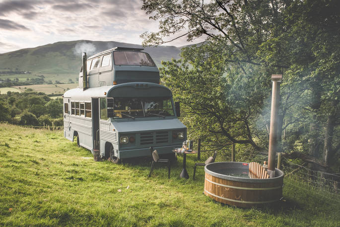 A converted bus, with a VW camper bedroom on the roof, in a remote corner of The Lake District