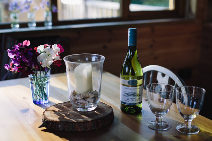 Two wine glasses alongside a bottle of Sauvignon Blanc white wine on the table in Netherby Treehouse