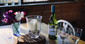Two wine glasses alongside a bottle of Sauvignon Blanc white wine on the table in Netherby Treehouse