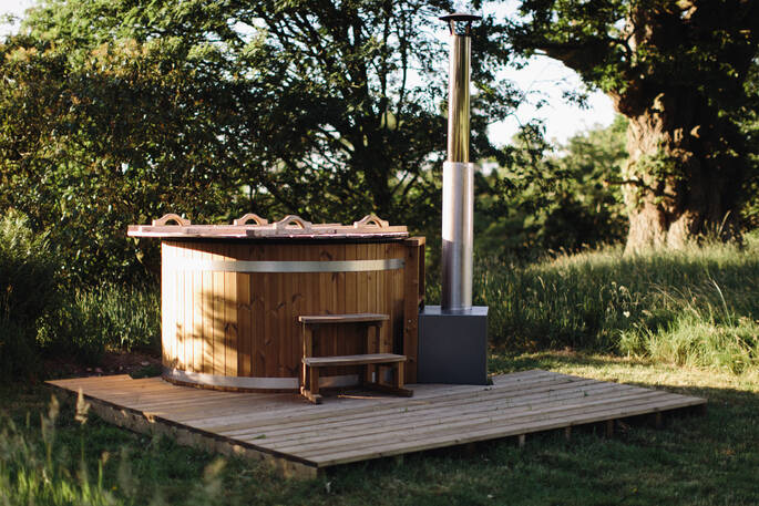 Relax and soak in the private wood fired hot tub at Netherby Treehouse in Cumbria, after a long day of exploring the surrounding countryside