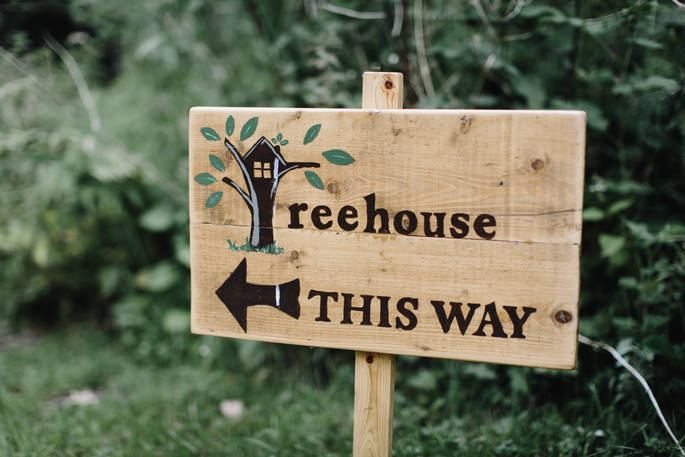 Quirky wooden sign pointing towards Netherby Treehouse at Netherby Estate in Cumbria