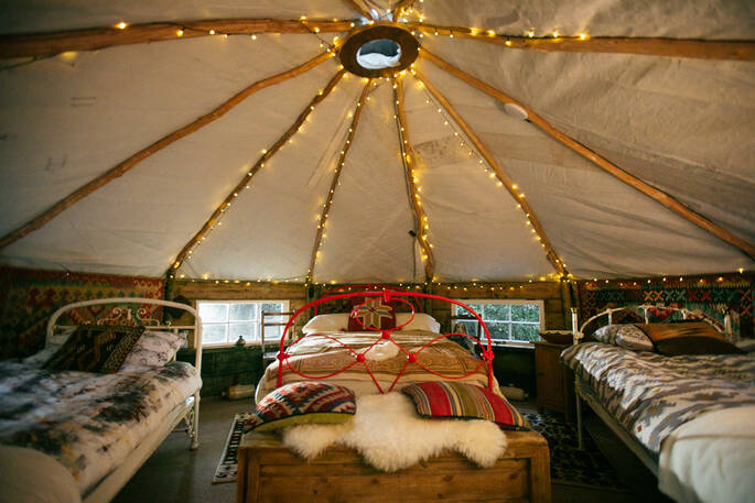 Inside the cosy and charming homemade yurt at Turners Woodland Suite, with comfortable double bed and two single beds
