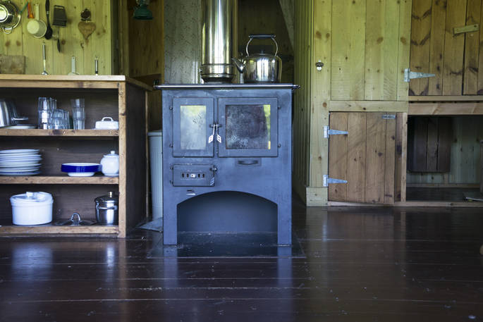 Fully-equipped kitchen area and log burner inside Duckpool Cabin, Berridon Farm, Devon