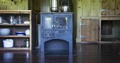 Fully-equipped kitchen area and log burner inside Duckpool Cabin, Berridon Farm, Devon