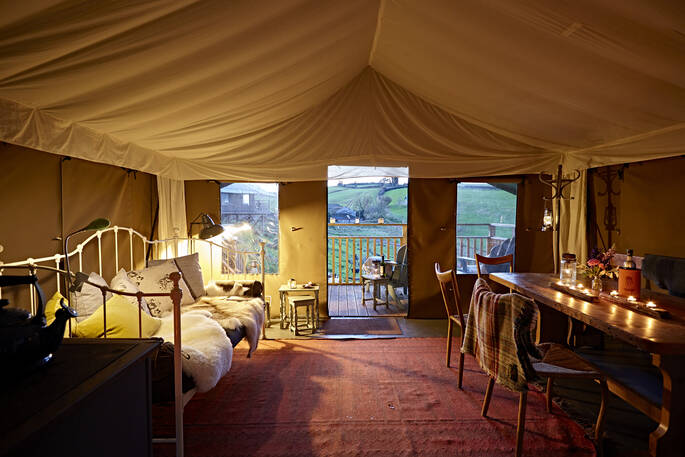 From out from interior of Bovey safari tent of deck and rolling hills at Brownscombe at dusks