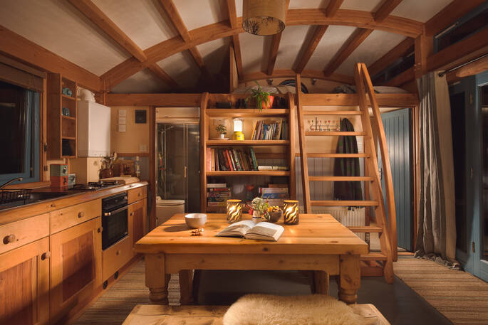 Stay cosy by the log burner on winter nights inside Carpenter Cabin at Devon Dens