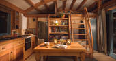 Stay cosy by the log burner on winter nights inside Carpenter Cabin at Devon Dens