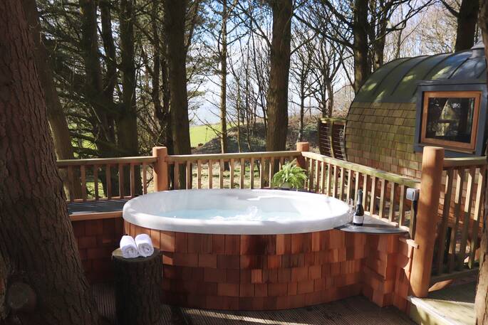 Soak in the hot tub on the deck at Loft Treehouse, Pickwell Manor, Devon