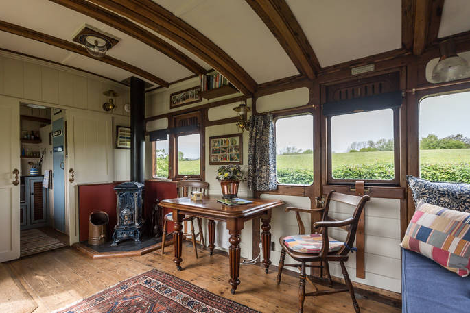 Cosy interior of Camping Coach, with woodburner and beautiful classic dining area