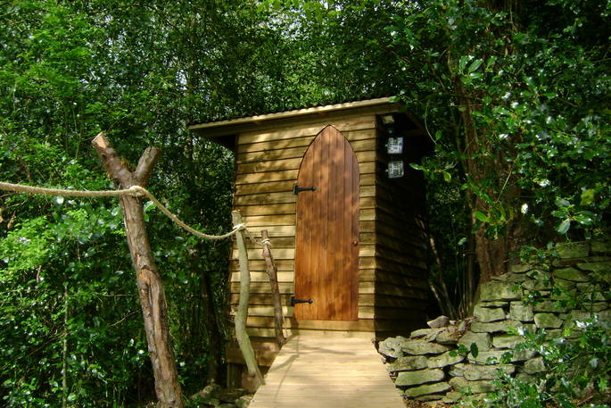 Sapperton Yurt wood cabin housing compost toilet hidden in the trees