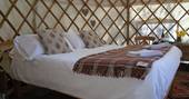 Relax in the comfortable kingsize bed at Cider Orchard Yurt in Gloucestershire