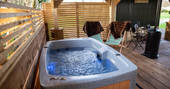 Hot tub on the decking next to Eden the shepherd's hut at The Wright Retreat in Gloucestershire
