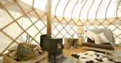 Sapperton Yurt interior with wood-burning stove and single futon bed
