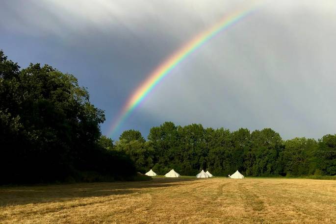 Rainbow over the camp at Mundays Meadow in Gloucestershire