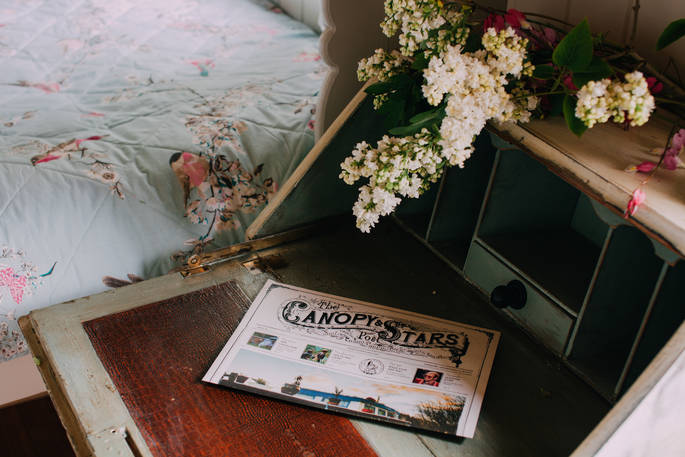The Canopy and Stars post sits upon the vintage bedside table adorned with flowers