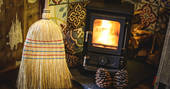 Roaring woodburner with decorative tiles inside Rowan Cabin in Northumberland 