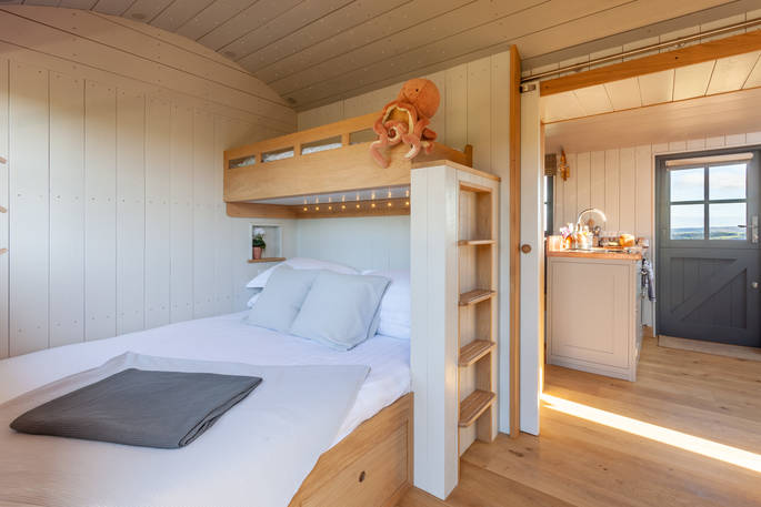 One double bed with single bunk bed above inside Maylies at Huts in the Hills in Northumberland 
