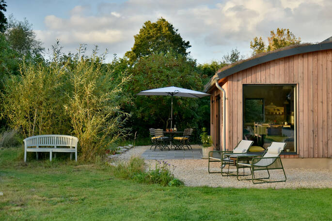 Garden is spacious with outdoor dining, sun loungers and a bench looking out the large field