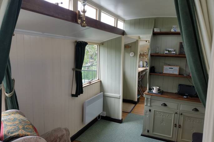 The cosy cottage-like interior of Green Fairground Wagon in Suffolk