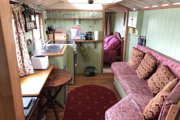 Kitchen and living area inside Maroon Fairground Wagon at Coppins Farm in Suffolk