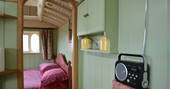Main bedroom with double bed inside Maroon Fairground Wagon at Coppins Farm in Suffolk