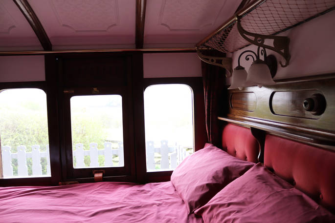 Double bed inside The Victorian Railway Carriage at Coppins Farm in Suffolk