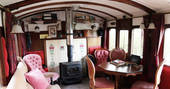 Light the wood-burner and sit inside The Victorian Railway Carriage at Coppins Farm in Suffolk