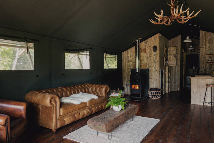 Interior of The Woodman's Lodge with wood-burner and fully equipped kitchen at The Lost Garden Retreat in Suffolk