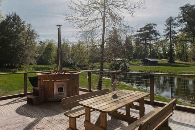 Wood-fired hot tub on the decking of The Woodman's Lodge at The Lost Garden Retreat in Suffolk
