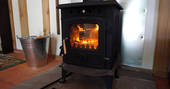 Warm yourself by the wood-burner in Anderida Cabin at Forest Garden in Sussex