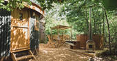 An exterior view of the Sussex Roundhouse with outdoor eating area and private wood fired hot tub