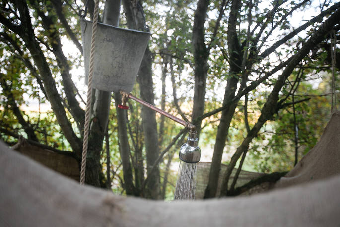 Bucket in a tree style shower on ground level at Puckshipton tree house in Wiltshire 