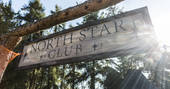 Sun filtering through the trees onto the North Star Club sign