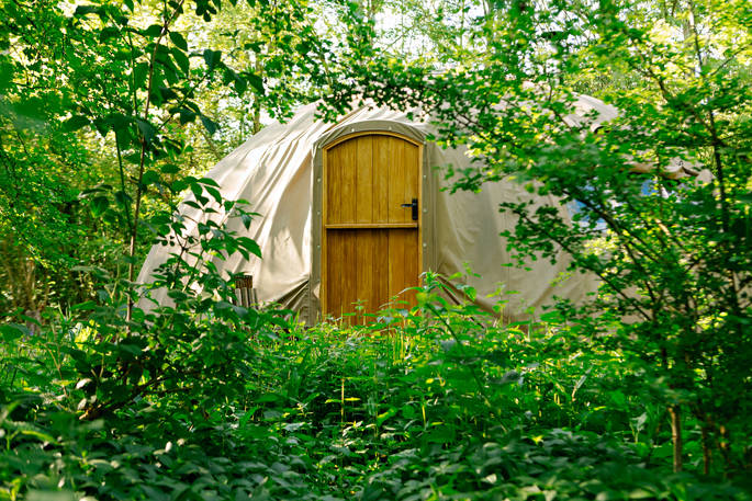The Slades tent at Penhein Glamping, seen through the trees