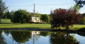 view of Rozanne roulotte across the pond at Coutillard in France 