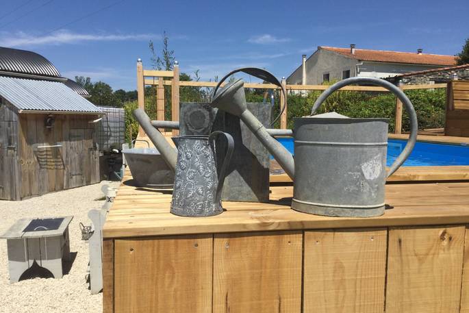 shepherd's hut holiday france watering cans by swimming pool